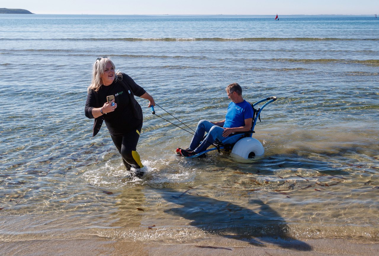 tilrettelagt friluftsliv på Jæren, strandvogn i sjøen blir dradd av kvinne mens mann sitter i vogna.
