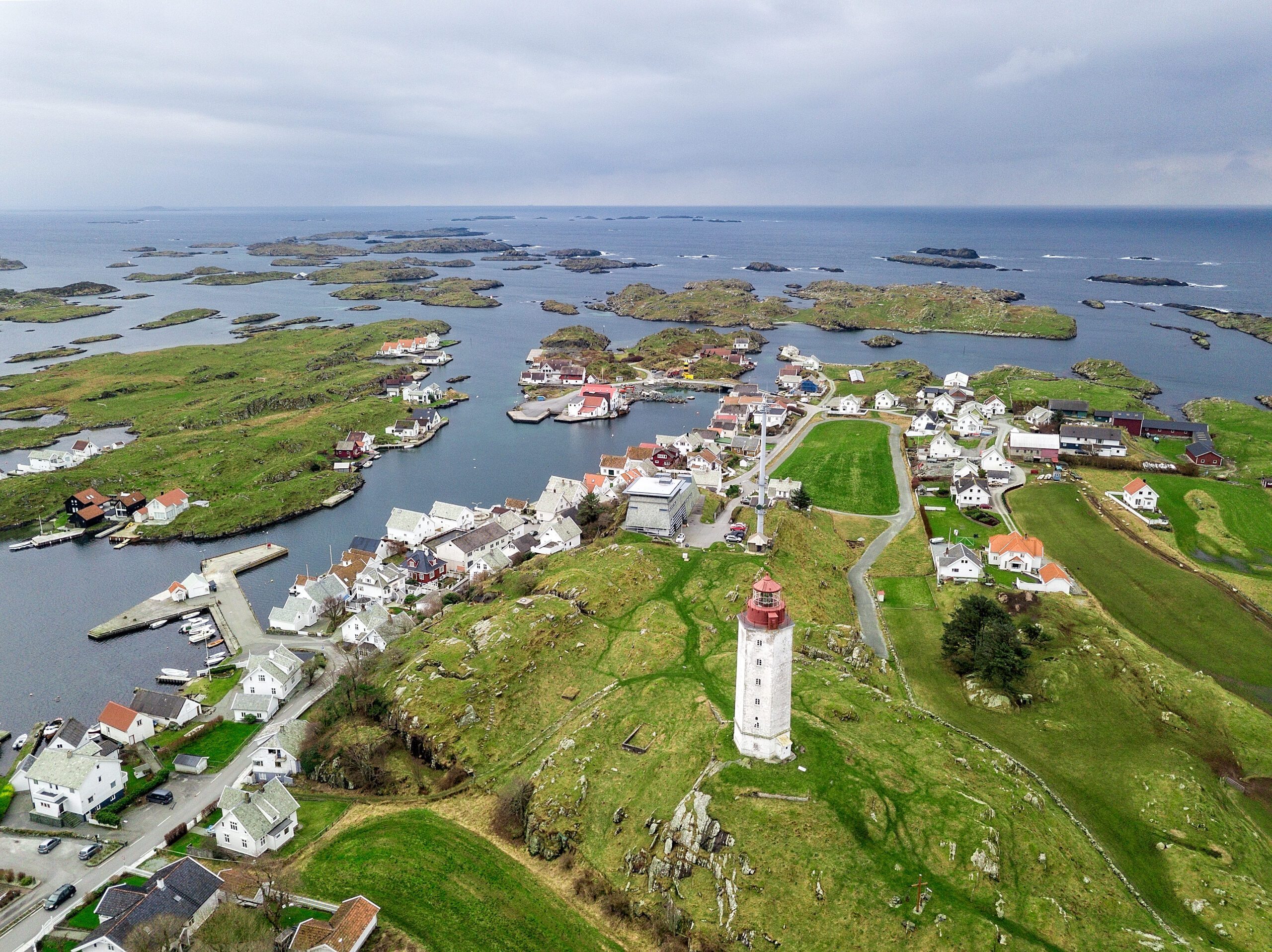 Dronebilde av Kvitsøy med fyret, havna og de små øyene rundt