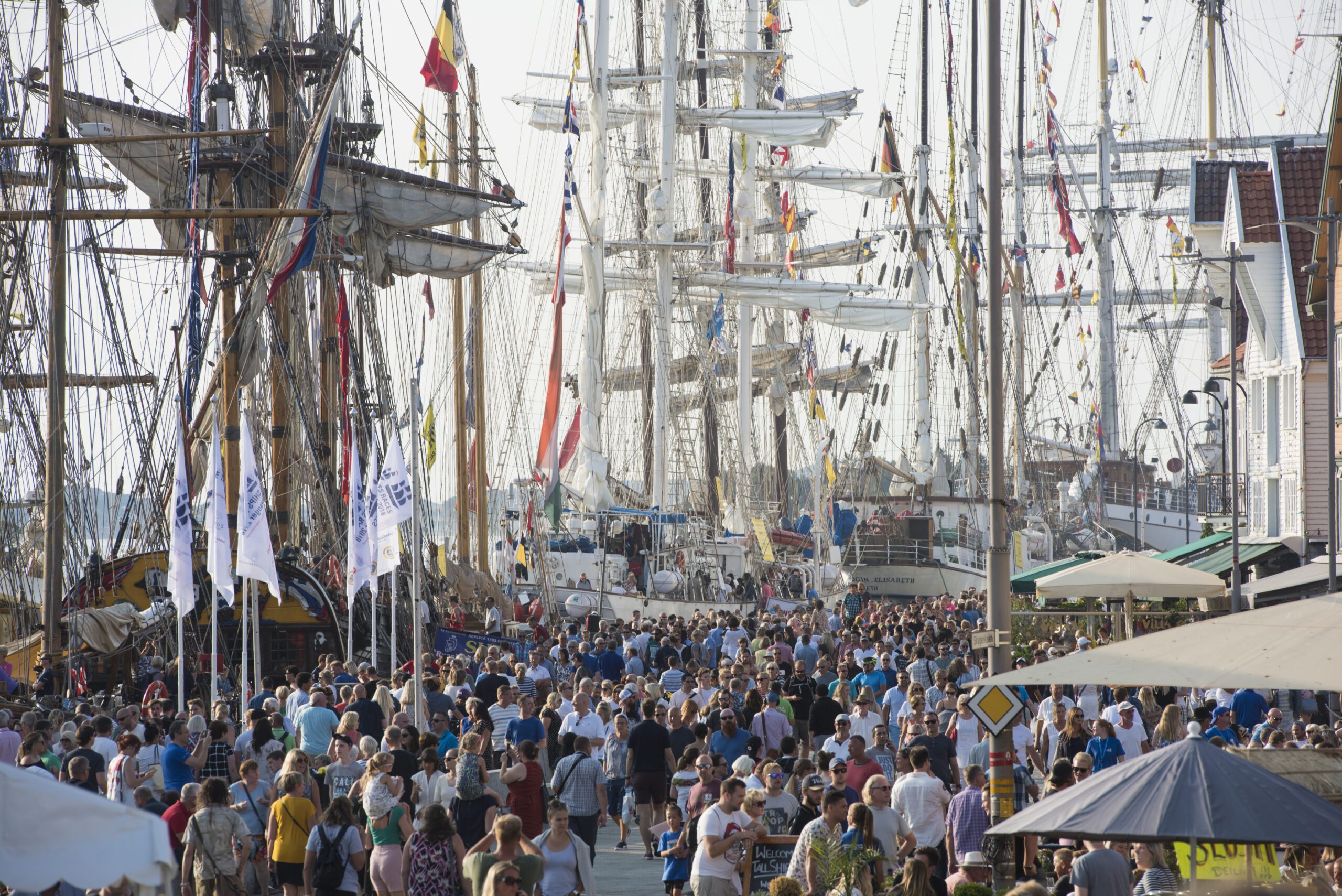 Seilskuter med master og flagg tett i tett i Vågen i Stavanger under The Tall Ships Races.